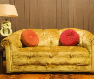 Retro style couch in older home with brown paneling on walls